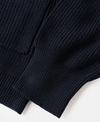 Close-up view of the rib knit texture and structured hem on a dark blue wool-blend cardigan sweater.