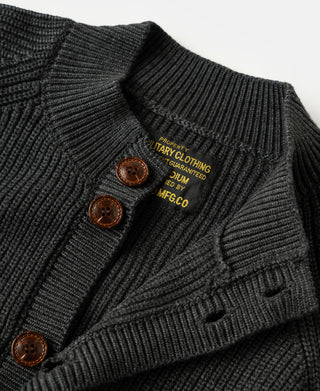 Detailed view of wooden buttons and textured knit fabric on a brown wool-blend cardigan sweater.