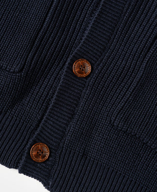 Close-up of wooden buttons and ribbed button placket on a heavyweight dark blue cardigan sweater.