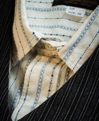 Close-up of shirt collar, neck label and blue stripe pattern