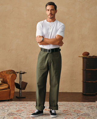 Olive fatigue pants on-model view showing relaxed straight leg and buttoned waistband.