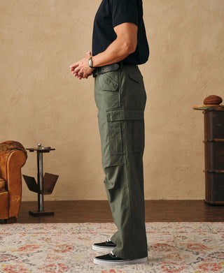 Olive field cargo trousers on model, side view with cargo pocket