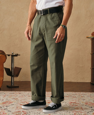 Olive fatigue pants on-body view with belt loops, tapered straight legs, and cuffed hem.