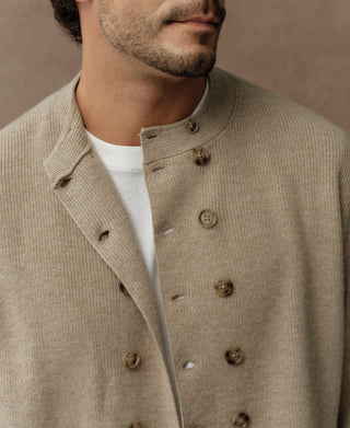 Ecru double-breasted knit cardigan with brown buttons and notch lapels
