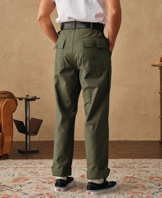 Olive fatigue pants with cargo pockets, belt loops, and button fly